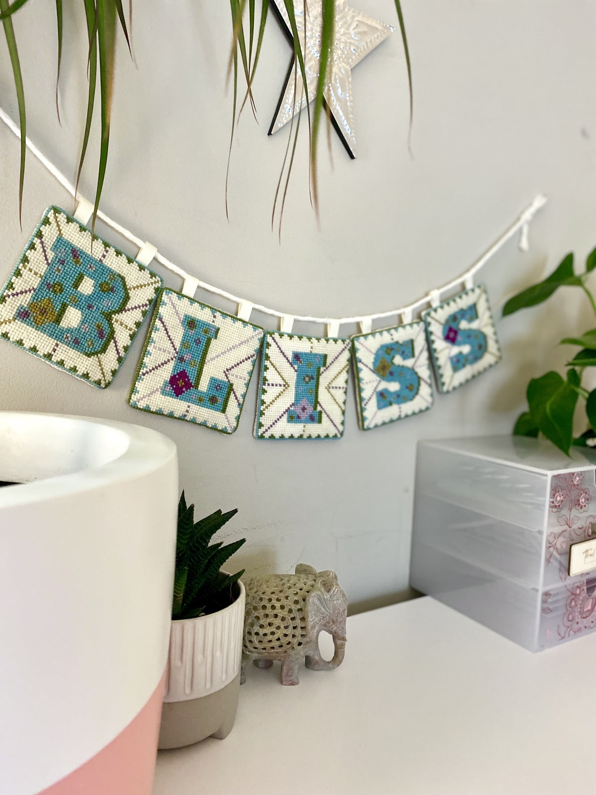 Finished tapestry letters made into a delightful bunting decoration spelling the word "Bliss".