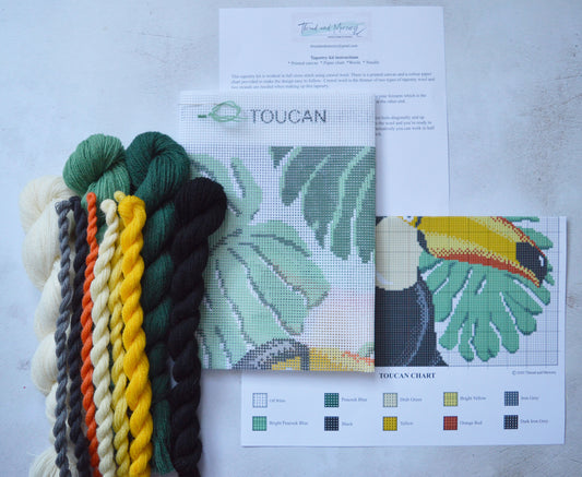 A printed canvas tapestry kit, featuring crewel wool, showcasing a lively toucan design with vibrant colors and intricate details, offering a fun and engaging project for crafters.