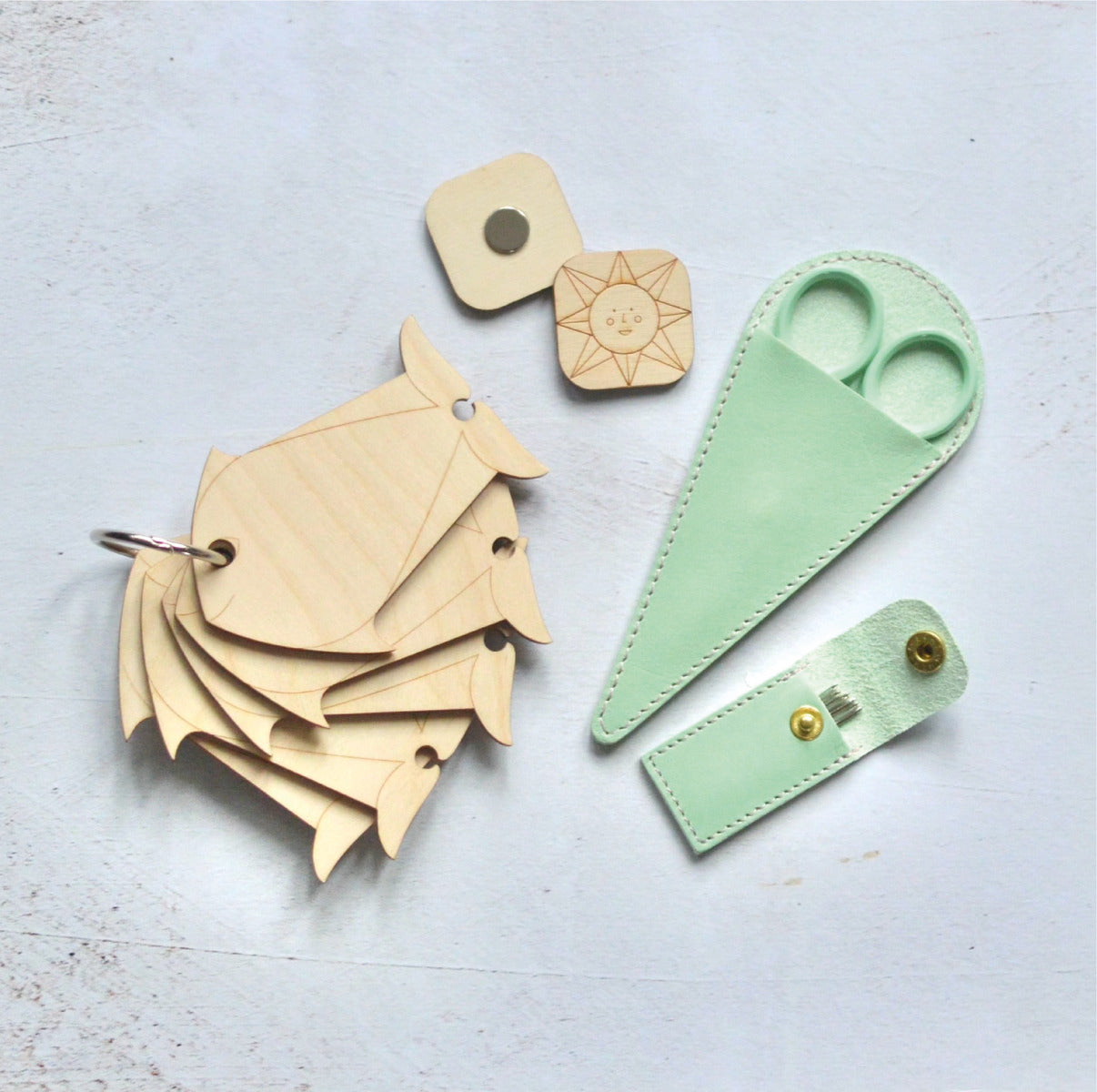Accessories for needlepoint in a beautifully presented gift box. Containing yarn bobbins, a magnetic needle minder, scissors and tapestry needles in a hand made leather case.
