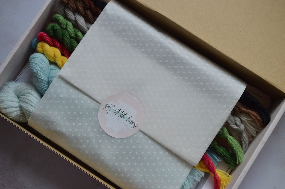 beautifully packaged and boxed tapestry kit with slogan "get stitch happy" printed on the sticker to evoke feelings of happiness when stitching