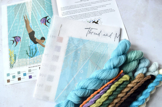 An image of the tapestry kit contents containing wool and a printed canvas and cross stitch instructions