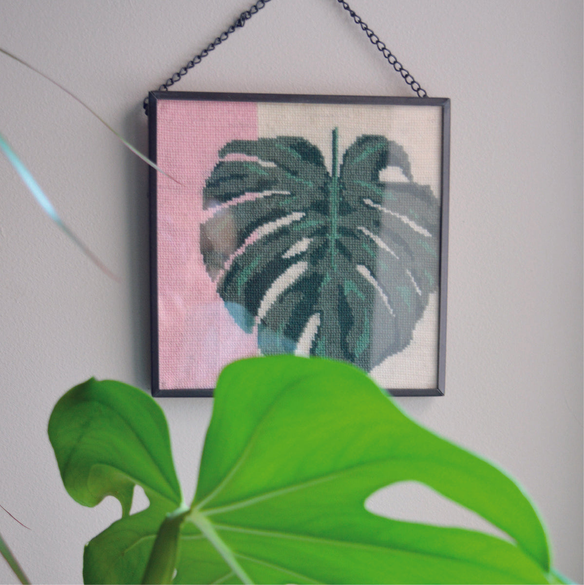 The modern monstera leaf tapestry kit  made into a striking picture once finished and framed.