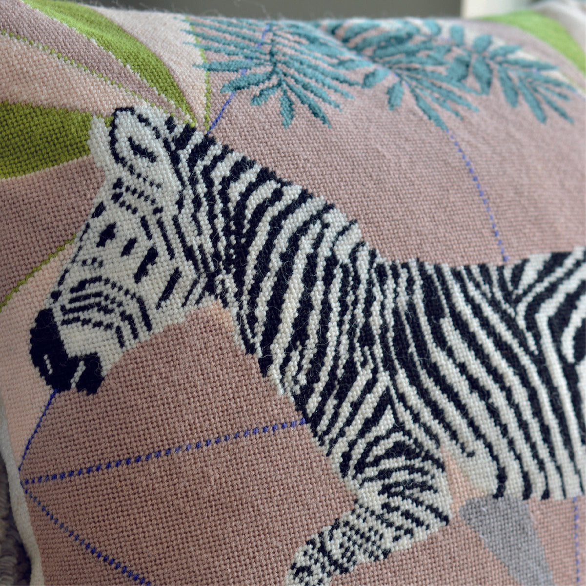 Close-up stitching detail of a zebra needlepoint kit, revealing the intricate pattern and meticulous craftsmanship, showcasing the beauty and texture of the finished tapestry cushion.