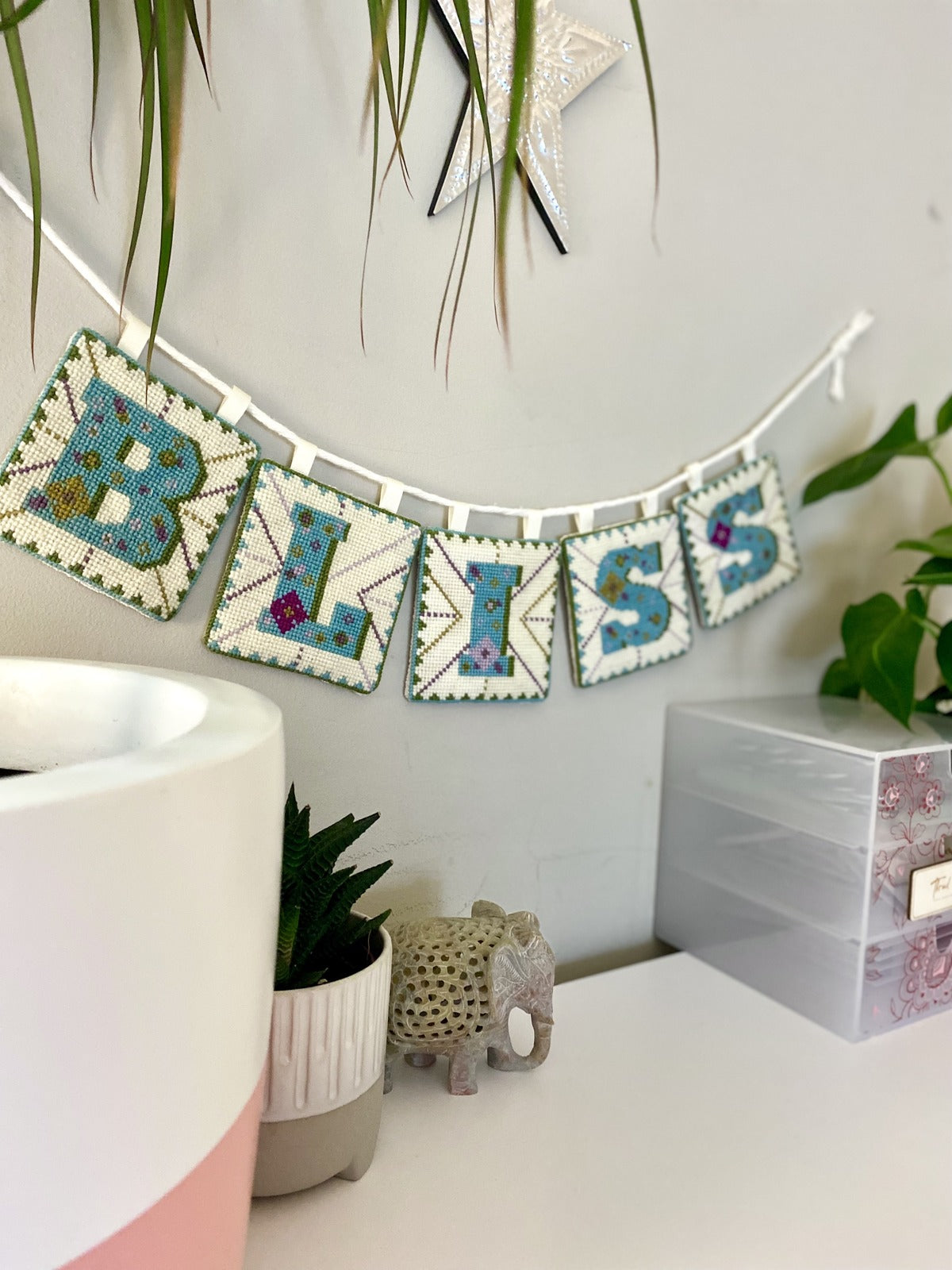 Finished tapestry letters made into a delightful bunting decoration spelling the word "Bliss".