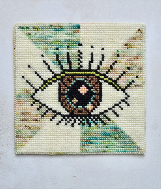 An image of an evil eye tapestry kit design, showcasing intricate patterns and vibrant colours. The tapestry depicts the iconic symbol of the evil eye as a protective motifs. Perfect for individuals seeking to incorporate spiritual or cultural symbolism into their home decor.