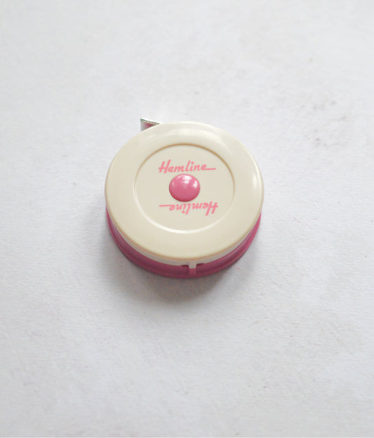 a retro tape measure in pink and cream