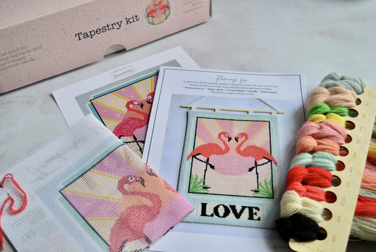 An image of a printed canvas tapestry kit featuring a flamingo design. The kit includes colourful wool threads ready for stitching. Perfect for craft enthusiasts looking to create a vibrant and eye-catching piece of wall art