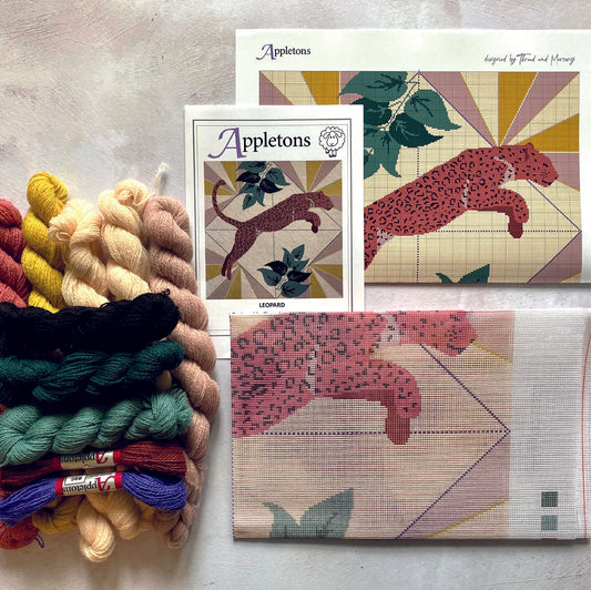 A leopard needlepoint kit with wool threads and a printed canvas, depicting a stunning leopard design with intricate details and rich colors