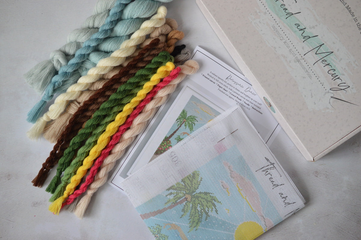 An image showing the contents of a wool tapestry kit including vibrant colours and a printed canvas