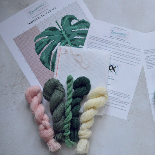 An image of a mini tapestry kit with wool, featuring a monstera leaf design. The kit provides all materials necessary to create a small-scale tapestry depicting a detailed monstera leaf, perfect for crafting enthusiasts looking to add a touch of tropical flair to their décor