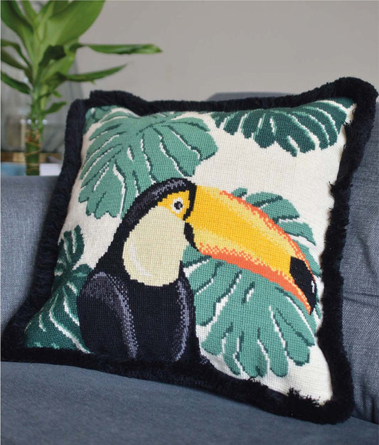 A tropical tapestry kit cushion featuring a colorful toucan design, with intricate stitching and rich textures, adding a tropical and playful accent to any space.