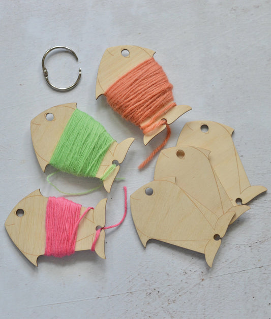 wooden yarn bobbins in fun fish shapes. shown to be used with crewel wool, tapestry wool or soft cotton thread